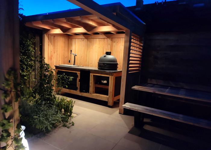 Buitenkeuken met tap en kamado in de avond