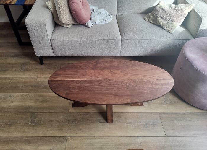 Ovale notenhouten salontafel voor de bank