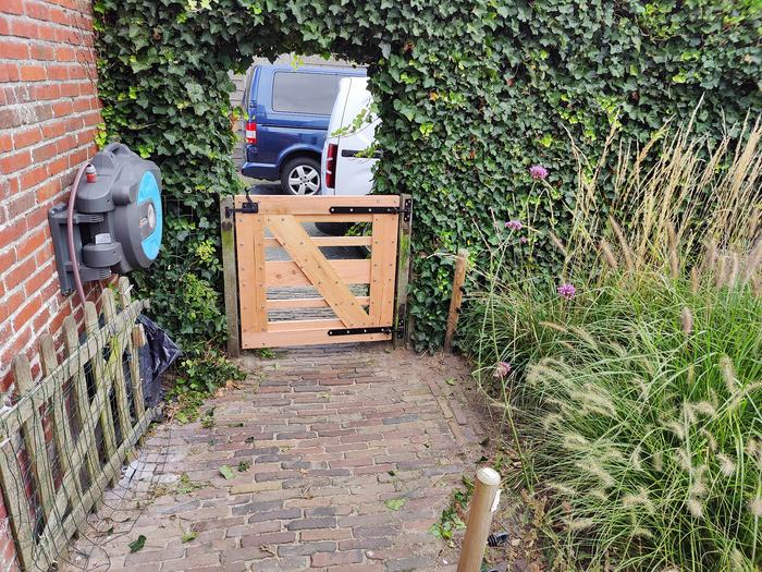 Houten tuinpoortje in een steeg