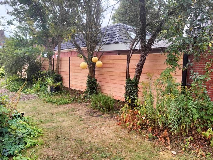 Horizontale houten schutting tussen de bomen