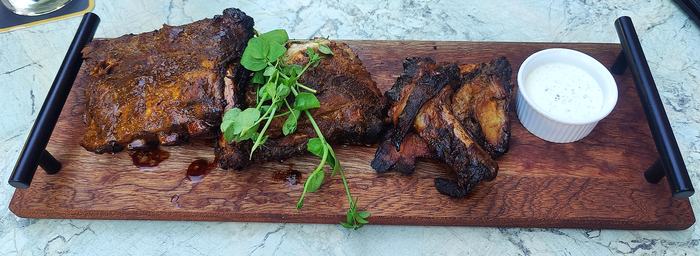Serveerplank met grepen in gebruik met spareribs